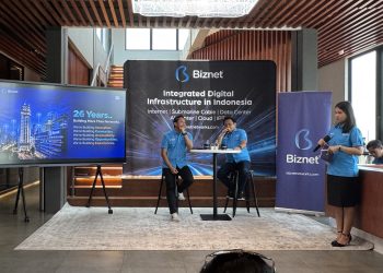 26 Tahun Biznet, Perkuat Infrastruktur Digital dan Hadirkan Inovasi Berbasis AI  SEMARANG – Memasuki usia ke-26 tahun, Biznet terus memperkuat perannya dalam mendukung transformasi digital Indonesia melalui pengembangan infrastruktur jaringan, pusat data berbasis kecerdasan buatan atau Artificial Intelligence (AI), hingga inovasi layanan pelanggan. Langkah ini menjadi bagian dari komitmen perusahaan untuk menghadirkan konektivitas yang andal sekaligus membuka lebih banyak peluang bagi masyarakat di era digital.  Selama lebih dari dua dekade, Biznet tidak hanya berfokus pada pembangunan jaringan internet, tetapi juga mengembangkan infrastruktur yang mampu menjawab kebutuhan teknologi masa depan. Sejumlah langkah strategis dilakukan, mulai dari pengoperasian AI-Ready Data Center di Bali hingga pengembangan jaringan kabel serat optik bawah laut Biznet Nusantara Cable System (BNCS) untuk memperkuat konektivitas antarpulau.  Kebutuhan terhadap infrastruktur digital berkapasitas besar semakin meningkat seiring pesatnya adopsi teknologi. Berdasarkan PwC Global Workforce Hopes & Fears Survey 2025, sebanyak 69 persen pekerja di Indonesia telah menggunakan AI untuk pekerjaan mereka dalam 12 bulan terakhir. Sementara itu, survei Asosiasi Penyelenggara Jasa Internet Indonesia (APJII) mencatat penetrasi internet Indonesia mencapai 81,72 persen pada 2026.  Perkembangan tersebut mendorong kebutuhan terhadap konektivitas yang tidak hanya cepat, tetapi juga didukung kapasitas komputasi dan pengolahan data yang semakin besar. Untuk menjawab tantangan tersebut, Biznet menghadirkan Biznet AI Center di Bali sebagai AI-Ready Data Center pertama milik perusahaan.  Fasilitas ini dirancang untuk mendukung kebutuhan komputasi berintensitas tinggi, terutama dalam menjalankan server AI. Berbeda dari pusat data konvensional, AI Center dilengkapi kapasitas daya listrik yang lebih besar, teknologi pendingin cair atau liquid cooling, serta konektivitas yang andal. Infrastruktur tersebut memiliki kapasitas daya hingga 145 kW per rak dan dilengkapi laboratorium pengembangan AI.  Kehadiran fasilitas ini diharapkan dapat menjadi fondasi bagi perkembangan ekosistem kecerdasan buatan di Indonesia. Dengan dukungan infrastruktur yang sesuai, pelaku usaha dan pelanggan dapat mengoptimalkan pemanfaatan teknologi AI untuk meningkatkan produktivitas, mengembangkan inovasi, serta mempercepat proses pengolahan data.  President Director Biznet, Adi Kusma, mengatakan bahwa perjalanan 26 tahun perusahaan menjadi momentum untuk terus menyesuaikan layanan dengan perkembangan kebutuhan masyarakat digital.  “Selama 26 tahun mendukung transformasi digital Indonesia, dalam perjalanannya, kami terus berupaya untuk dapat menjawab kebutuhan masyarakat digital. Kami memahami betul bahwa saat ini kebutuhan digital tidak terbatas pada konektivitas semata, namun juga kapasitas besar untuk mengakselerasi segala kegiatan komputasi dan pengolahan data yang lebih besar untuk mendukung implementasi AI yang sedang berkembang saat ini,” jelas Adi.  Selain memperkuat infrastruktur pusat data, Biznet juga mengembangkan konektivitas antarpulau melalui Biznet Nusantara Cable System (BNCS), jaringan kabel serat optik bawah laut yang dibangun, dimiliki, dan dioperasikan sendiri sejak 2024. Infrastruktur ini menjadi bagian dari upaya perusahaan meningkatkan kapasitas jaringan sekaligus mendukung pemerataan akses internet berkualitas di Indonesia.  Biznet kini menyiapkan pembangunan jaringan kabel bawah laut baru, yakni Biznet Nusantara Cable System-2 (BNCS-2). Jaringan tersebut direncanakan menghubungkan Surabaya di Pulau Jawa, Banjarmasin di Kalimantan, Sumenep di Madura, serta Buleleng di Bali.  Pengembangan BNCS-2 diharapkan mampu meningkatkan kecepatan dan kualitas layanan di wilayah yang terhubung. Bagi Biznet, pembangunan jaringan bawah laut bukan sekadar menghubungkan satu wilayah dengan wilayah lainnya, melainkan juga menciptakan infrastruktur yang mendukung pertumbuhan aktivitas ekonomi dan membuka kesempatan lebih luas bagi masyarakat.  “Kami percaya bahwa membangun jaringan bukan hanya tentang menghubungkan satu titik wilayah dengan wilayah lainnya. Karena itu, infrastruktur yang kami bangun seperti Biznet Nusantara Cable System ini diharapkan mampu menciptakan pengalaman layanan yang lebih optimal bagi pelanggan serta membuka lebih banyak peluang dan kesempatan di era digital saat ini,” tambah Adi.  Sejalan dengan penguatan infrastruktur utama, Biznet terus memperluas jangkauan jaringan ke berbagai daerah. Saat ini, jaringan perusahaan telah menjangkau lebih dari 200 kota dan kabupaten di Pulau Jawa, Bali, Sumatra, Bangka, Batam, Kalimantan, Sulawesi, dan Flores. Jangkauan tersebut didukung lebih dari 3 juta homepass serta lebih dari 300 kantor cabang untuk mendekatkan layanan kepada pelanggan.  Komitmen memperluas akses digital juga diwujudkan melalui program tanggung jawab sosial perusahaan atau Corporate Social Responsibility (CSR). Pada 2026, Biznet memberikan layanan internet gratis kepada lebih dari 300 kepala keluarga di sekitar lokasi Biznet MarinePOP, yakni titik pendaratan kabel bawah laut perusahaan. Program tersebut menjangkau masyarakat di Kabupaten Jembrana, Kabupaten Serang, Kabupaten Karawang, dan Kabupaten Gresik.  Melalui inisiatif ini, Biznet berupaya agar manfaat pembangunan infrastruktur digital dapat dirasakan tidak hanya oleh pelanggan, tetapi juga oleh masyarakat yang tinggal di sekitar fasilitas jaringan. Akses internet diharapkan dapat membantu warga memperoleh informasi, mendukung kegiatan belajar, menjalankan pekerjaan, serta membuka peluang pengembangan ekonomi di lingkungan masing-masing.  “Bagi kami konektivitas bukan hanya tentang menyediakan akses Internet, tetapi juga membuka kesempatan bagi masyarakat untuk belajar, bekerja, mendapatkan informasi, dan berkembang di era digital saat ini. Karena itu, melalui program CSR ini, kami ingin menghadirkan manfaat konektivitas secara lebih luas, khususnya bagi masyarakat di sekitar infrastruktur Biznet. Inisiatif ini menjadi bagian dari komitmen kami untuk terus membangun infrastruktur digital yang tidak hanya menghubungkan lebih banyak orang, tetapi juga menciptakan peluang dan memberikan nilai lebih bagi setiap individu,” lanjut Adi.  Di sisi pengalaman pelanggan, Biznet terus mengembangkan MyBiznet App sebagai sarana untuk memudahkan pengguna mengelola layanan, memperoleh informasi, mengakses berbagai promosi, hingga mendapatkan dukungan layanan pelanggan. Aplikasi tersebut juga terus dikembangkan dengan pemanfaatan teknologi AI agar informasi dan solusi yang dibutuhkan pelanggan dapat diberikan secara lebih cepat, responsif, dan personal.  Sebagai bentuk apresiasi atas kepercayaan pelanggan, Biznet menghadirkan program Biznet Prize Vaganza yang memberikan kesempatan kepada pelanggan Biznet Home dan Biznet Metronet untuk memperoleh berbagai hadiah. Hadiah yang ditawarkan mencakup merchandise eksklusif Biznet, Apple Watch, iPad, PlayStation 5, voucher menginap di Rimba by AYANA Bali, MacBook Neo, hingga hadiah utama berupa emas seberat 10 gram, 25 gram, dan 100 gram.  Khusus dalam rangka perayaan ulang tahun ke-26 pada Oktober 2026, Biznet juga memberikan peningkatan kapasitas bandwidth menjadi 100 Mbps selama satu bulan tanpa biaya tambahan bagi pelanggan Biznet Home. Program ini menjadi bagian dari upaya perusahaan untuk menghadirkan konektivitas berkapasitas besar sekaligus memberikan pengalaman internet yang semakin optimal.  “Bagi kami, 26 tahun bukan hanya tentang seberapa jauh kami melayani masyarakat, tetapi juga tentang apa yang dapat kami berikan ke depannya. Karena itu, kami akan terus berinvestasi pada infrastruktur, teknologi, dan pengalaman pelanggan untuk menciptakan lebih banyak nilai serta mendukung Indonesia menjadi semakin terhubung,” tutup Adi.  Memasuki usia ke-26 tahun, Biznet menegaskan komitmennya untuk terus berinovasi melalui pengembangan infrastruktur, perluasan jaringan, dan peningkatan kualitas layanan. Dengan menggabungkan konektivitas, kesiapan infrastruktur AI, serta program yang memberikan manfaat langsung kepada masyarakat, Biznet berupaya mengambil bagian dalam membangun ekosistem digital Indonesia yang semakin inklusif, produktif, dan siap menghadapi tantangan masa depan.
